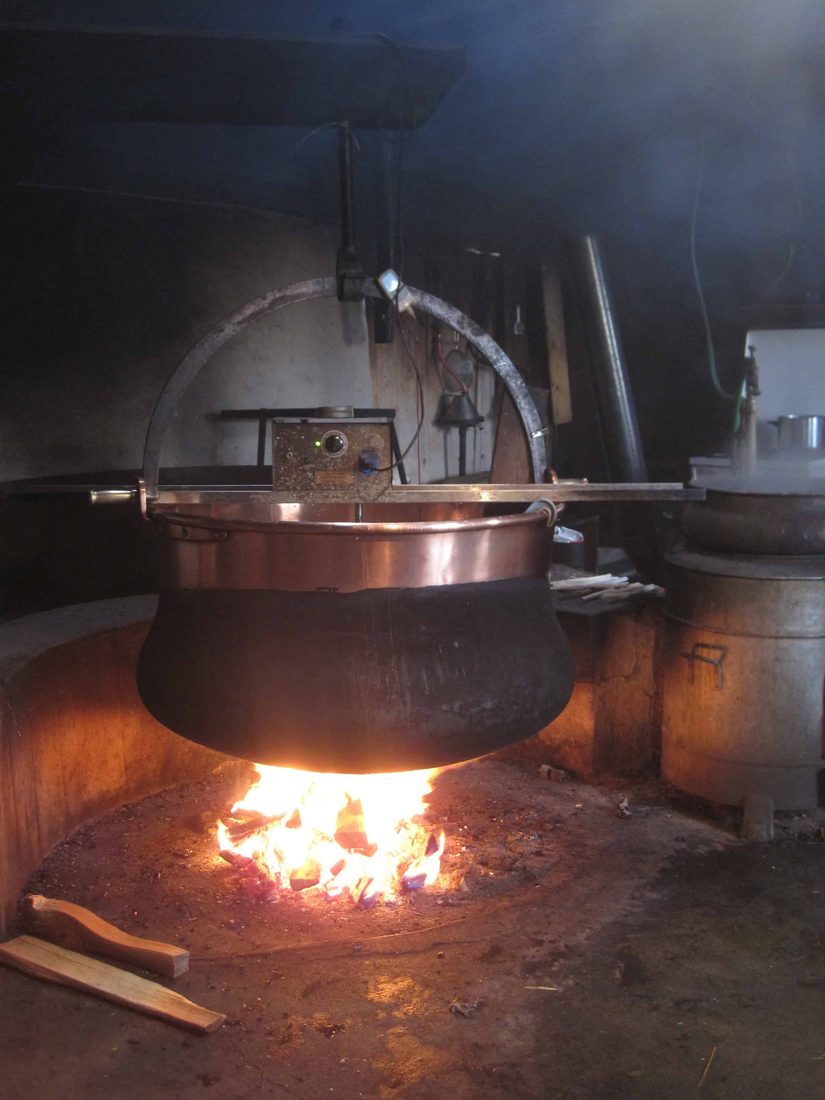 Kupferkessel über offenem Holzfeuer in einem Alpchalet